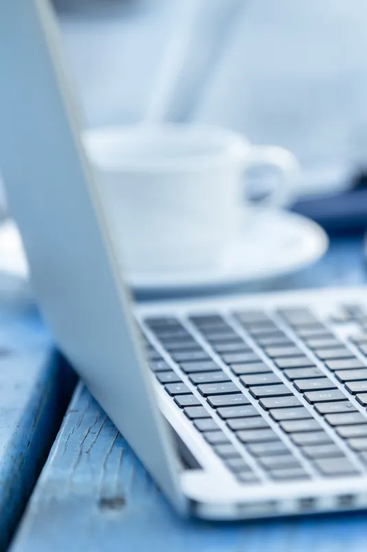 geöffneter Laptop mit Kaffee und Smartphone