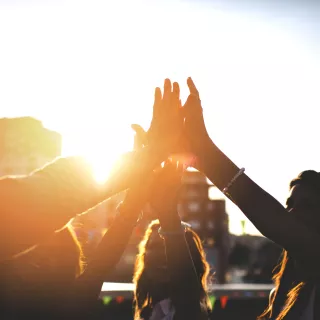 Happy friends at the rooftop doing high five