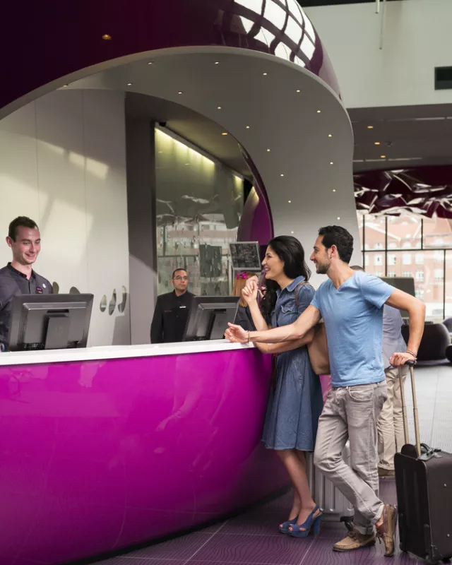 Junges Paar beim Check-in im Hotel