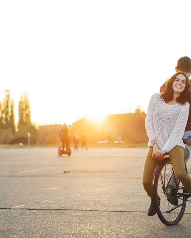 Junge Leute auf einem Rad auf dem Tempelhofer Feld Junge Leute auf einem Rad auf dem Tempelhofer Feld