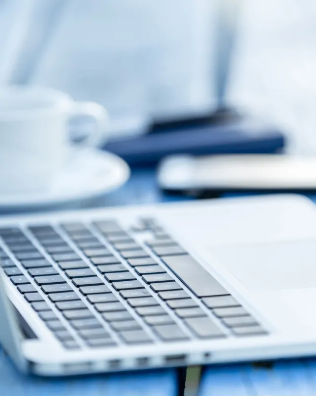 Foto: geöffneter laptop mit Kaffee und Smartphone