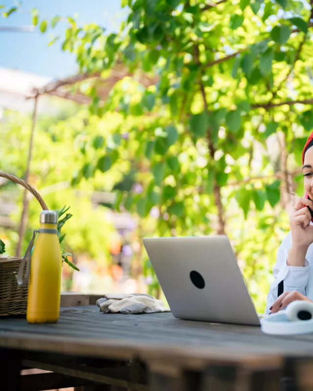 Headerbild: Frau beim Online-Seminar des TourismusHub in einem Garten