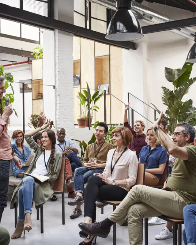 Business people with raised arms during seminar