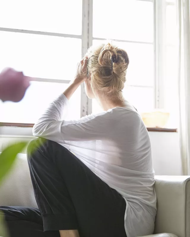 Woman sitting in front of window looking out