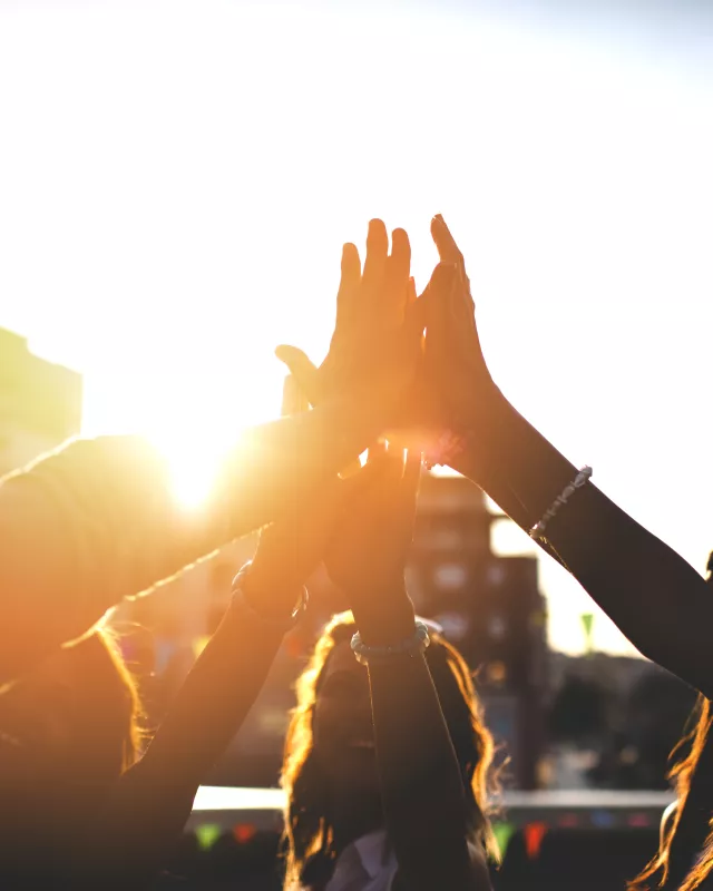 Happy friends at the rooftop doing high five