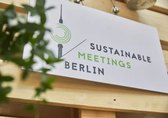 BIld einer Holztafel mit dem Sustainable Meetings Berlin Logo