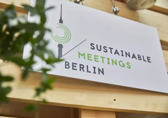 Sustainable Meetings Berlin BIld einer Holztafel mit dem Sustainable Meetings Berlin Logo