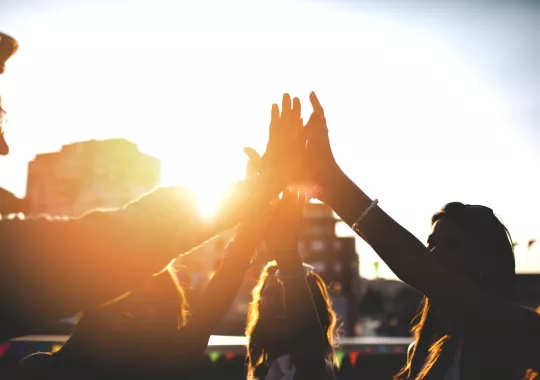 Happy friends at the rooftop doing high five