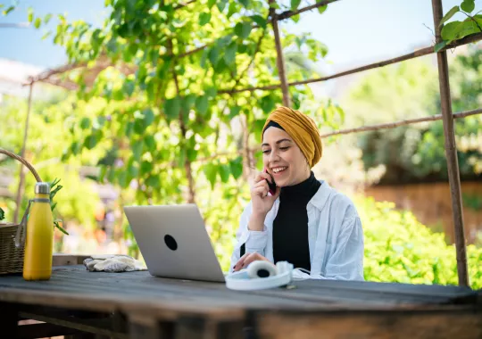 Frau beim Online-Seminar des TourismusHub in einem Garten