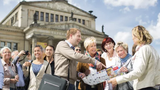 Reisegruppe vor Französischem Dom, Stadtplan in der Hand