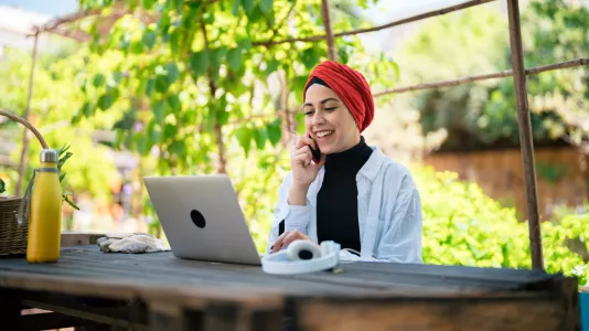 Headerbild: Frau beim Online-Seminar des TourismusHub in einem Garten