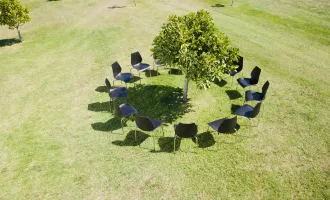 Sustainable Meetings Berlin, Green Meetings Berlin, Stuhlkreis um einen Baum auf grüner Wiese