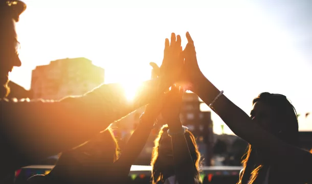 Happy friends at the rooftop doing high five