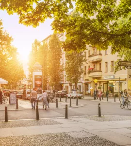 Kollwitzplatz mit Sonnenschein, Menschen schlendern über Straße