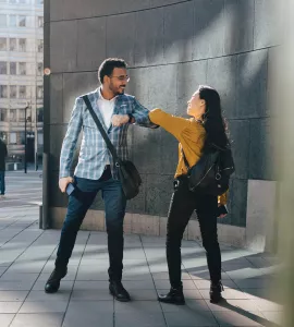 Teilnehmende begrüßen sich mit Ellbogen-Check