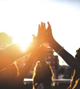 Happy friends at the rooftop doing high five