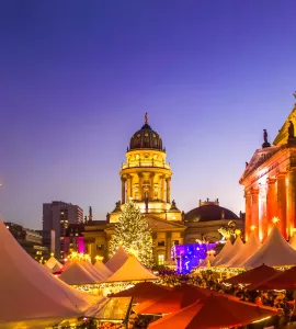 Tents Outside Neue Kirche Against Sky In City During Christmas