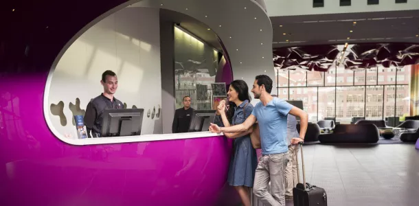 Foto: Junges Paar checkt in ein Hotel ein