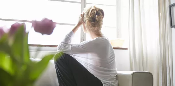 Woman sitting in front of window looking out