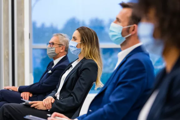 Teilnehmer mit Maske während einer Business Konferenz