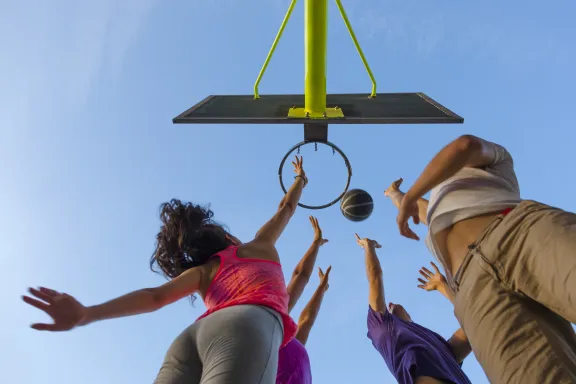 Group of Friends Jumping for a  Basketball